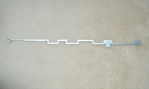 This item is a steel needle used in a circular knitting machine for textile manufacturing.