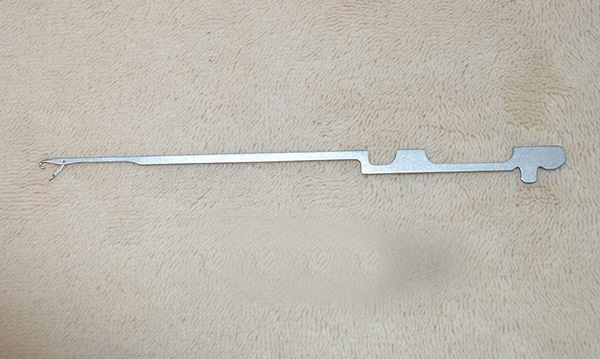 This item is a industrial knitting machine needle, specifically designed for circular or flat knitting machines, used in textile manufacturing.